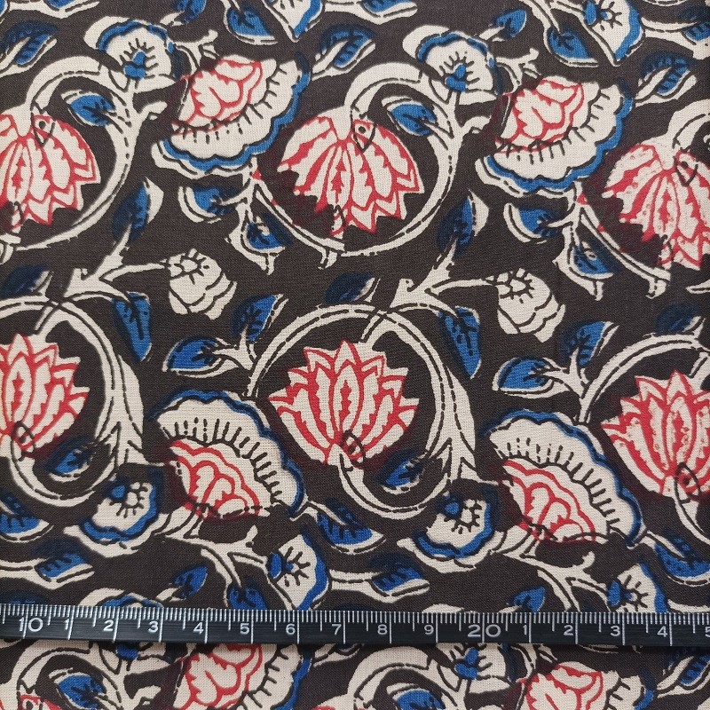 Tissu indien en voile de coton à motifs de fleurs bordeaux, beiges et bleues sur fond noir vendu à la coupe par Maison Pouic
