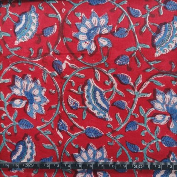 Indiennes à motifs de fleurs et tiges bleues sur fond rouge vendue à la coupe par Maison Pouic