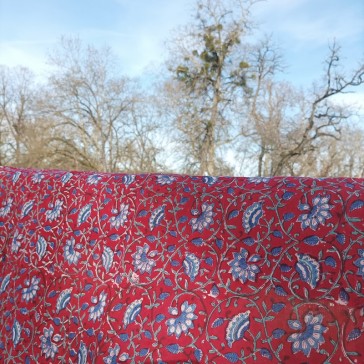 Coton indien à fond rouge avec des fleurs et des tiges bleues vendu à la coupe