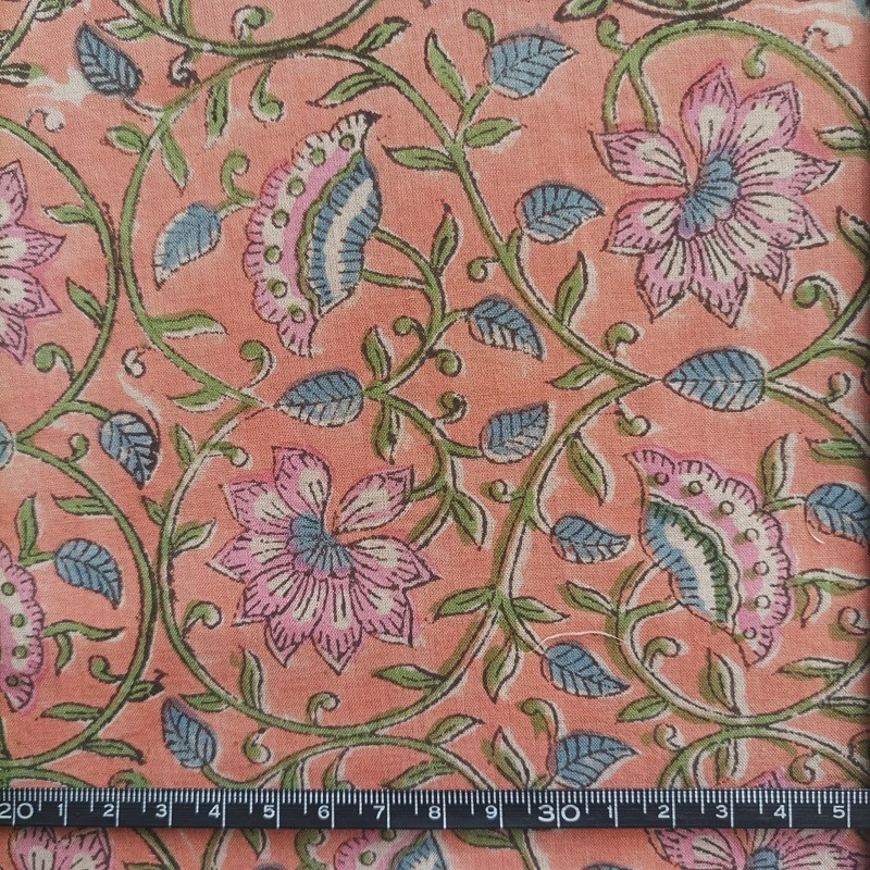 Indienne en voile de coton représentant des entrelacs de fleurs roses sur un fond couleur pêche