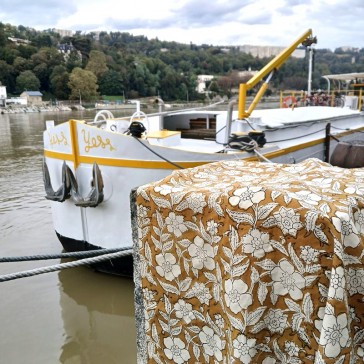 Tissu indien imprimé au tampon de bois à fleurs blanches cernées de noir sur fond moutarde