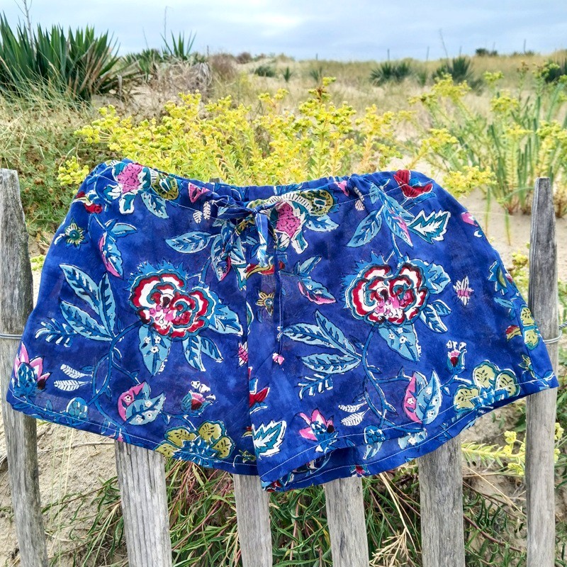 Short en coton indien à fleurs bleues et rouges sur fond bleu par Maison Pouic Short en coton indien à fleurs bleues et rouges sur fond bleu par Maison Pouic