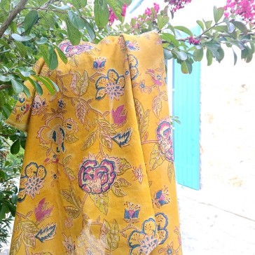 Tissu indien en coton avec grandes fleurs bleues et roses sur fond moutarde