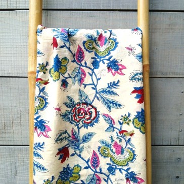 Tissu indien à grandes fleurs rouges et vertes avec feuilles et tiges bleues sur fond écru, vendu à la coupe par Maison Pouic