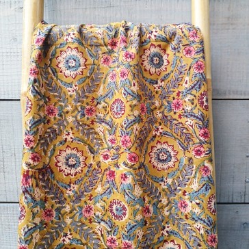 tissu indien fond moutarde et fleurs roses et bleues.