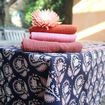 Tissu indien BL-322 à motif répété de fleurs beiges cernées de rouille sur fond noir.