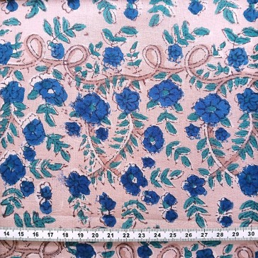 Petites fleurs bleu marine et feuilles vertes sur un fond rose.