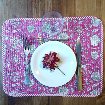 Set de table matelassé réversible fond rose à fleurs blanches.