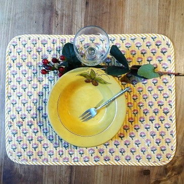 Set de table matelassé et réversible motifs floraux rose et vert sur fond jaune.
