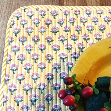 Set de table matelassé réversible fleuri sur fond jaune par Maison Pouic.