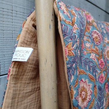 Couverture en coton indien fleuri fond bleu doublé de gaze de coton camel, pompons beiges et ouatine.