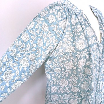 Top manches 3/4 à fleurs blanches sur fond bleu clair.