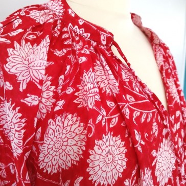 Top en coton indien à manches 3/4 à fleurs blanches sur fond rouge.