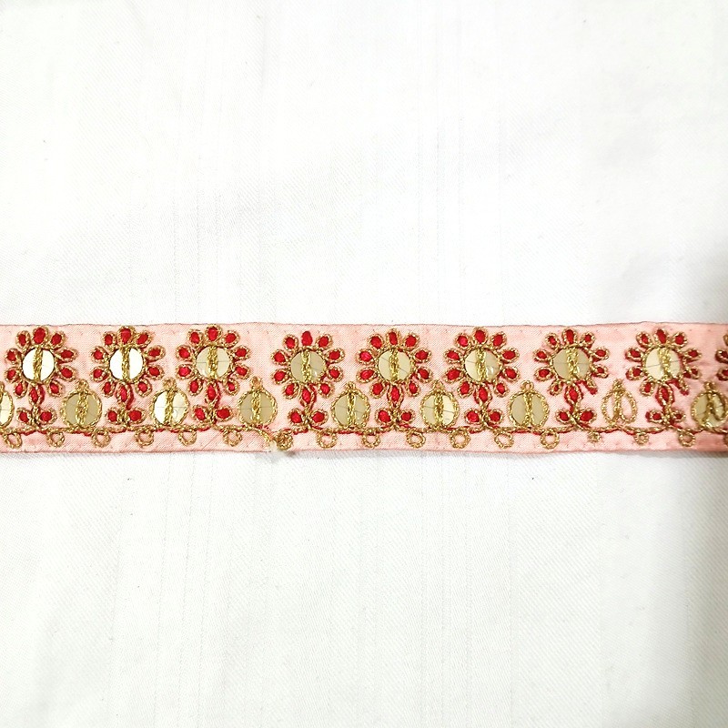 Ruban indien rose brodé de fleurs rouges, or et de petits miroirs vendu à la coupe